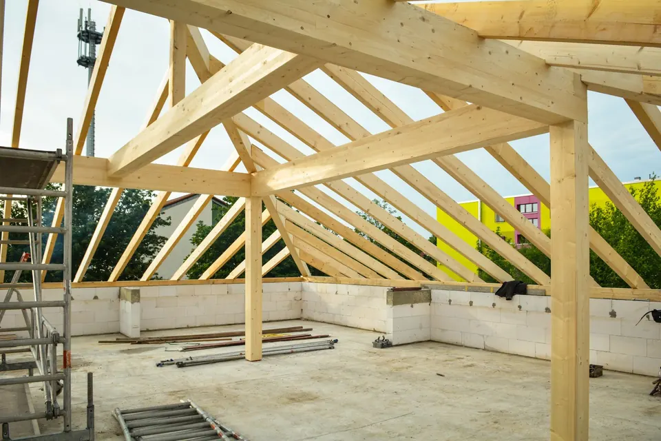 Charpente en bois neuve en cours de montage au-dessus d'une dalle