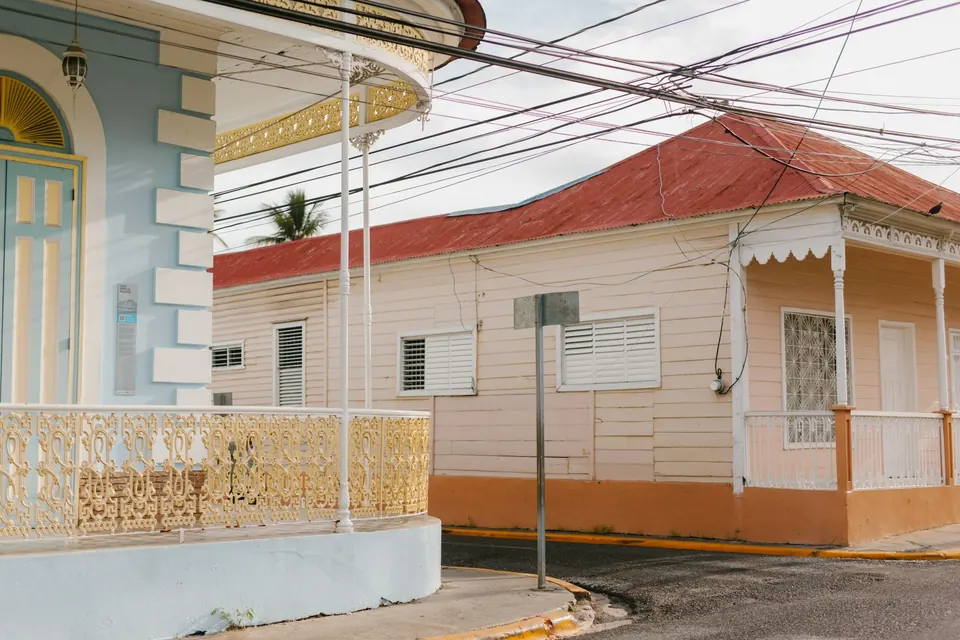 Maisons anciennes aux balcons ouvragés et au toit de tôle rouge, à un carrefour