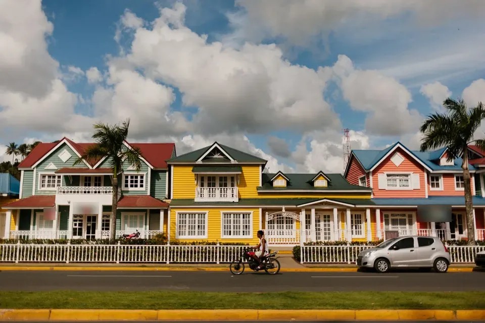 Rangée de maisons en bois colorées derrière une clôture blanche