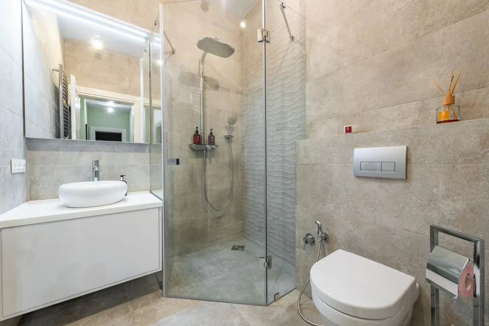 Salle d'eau avec douche vitrée, meuble vasque et WC suspendu